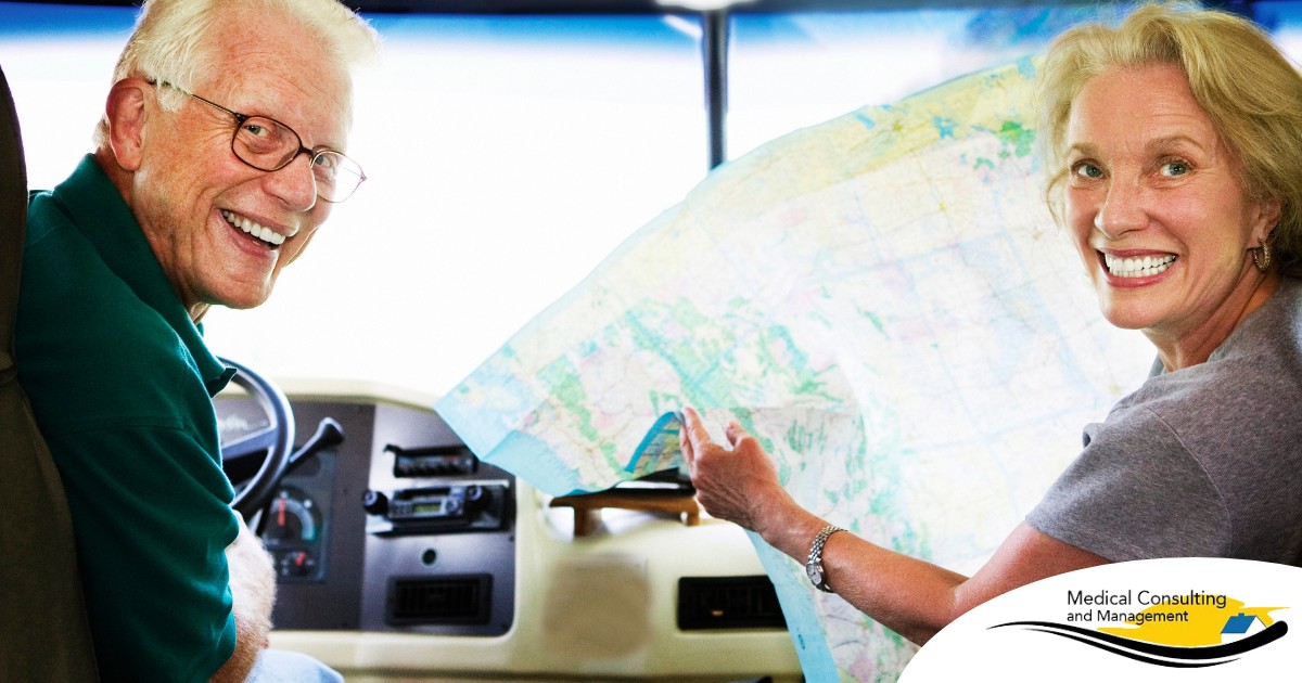 An older couple looks back smiling from the front of an RV, representing how day trips for seniors can help boost the mood of everyone.