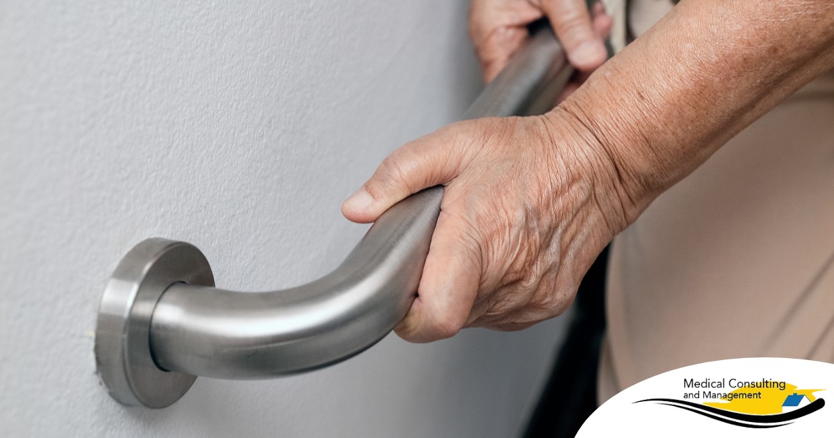 An older adult uses a grab bar representing one of the home modifications that is helpful for fall prevention for elderly adults.