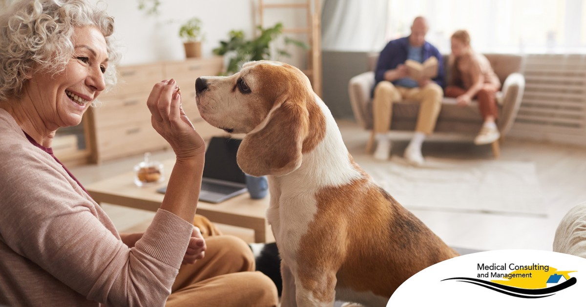 An older woman smiles while giving a dog a treat, representing the joy that dogs can bring.