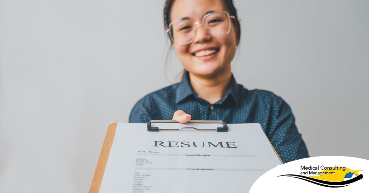 A woman happily hands in a resume, representing a successfully written caregiver resume.
